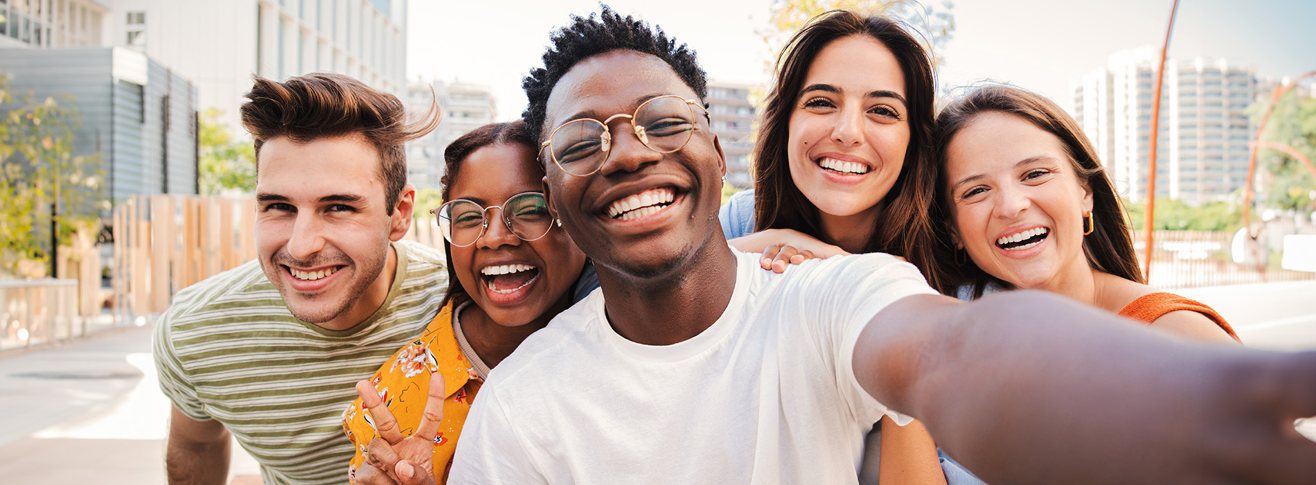 The image shows a group of five individuals posing together for a selfie with smiles on their faces.