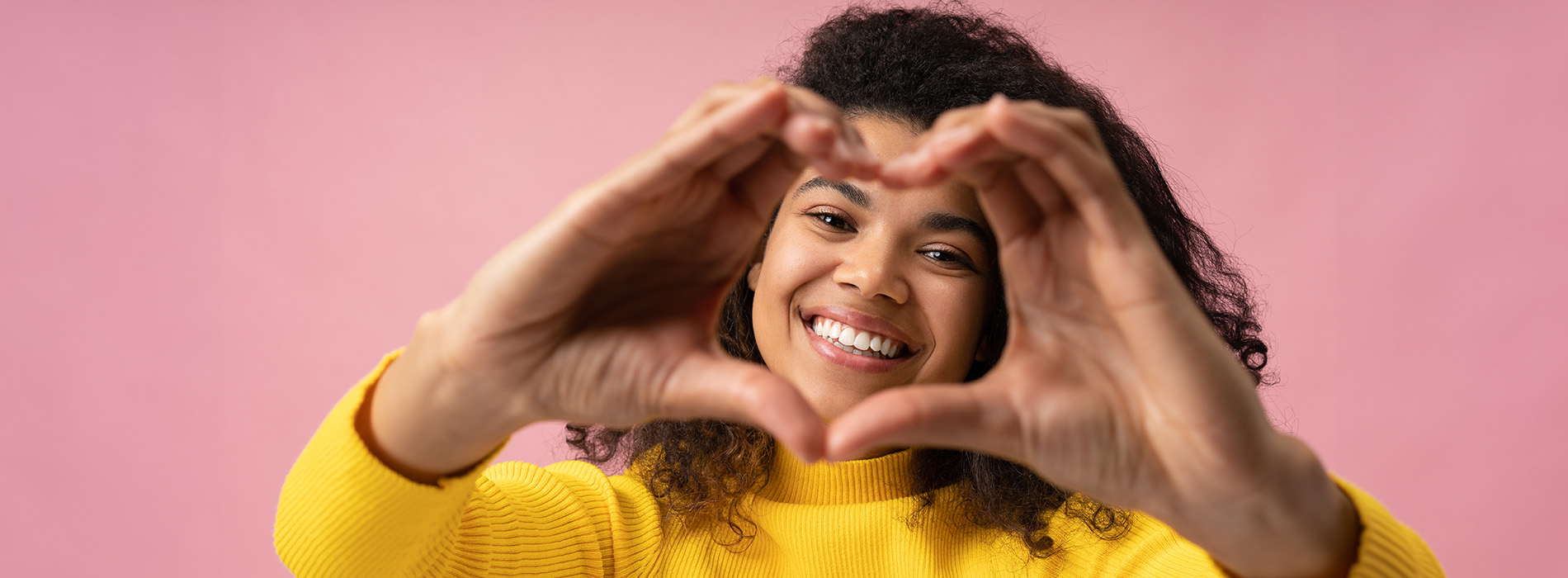 The image shows a group of people, possibly professionals given their attire and the setting that appears to be an office or professional environment. They are gathered around a table with a laptop on it, engaged in what seems to be a discussion or meeting.