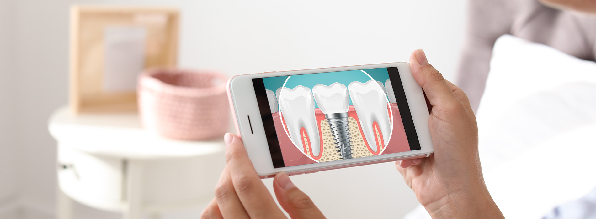 A person holding a smartphone displaying an animated graphic of teeth, with two toothbrushes visible in the background.