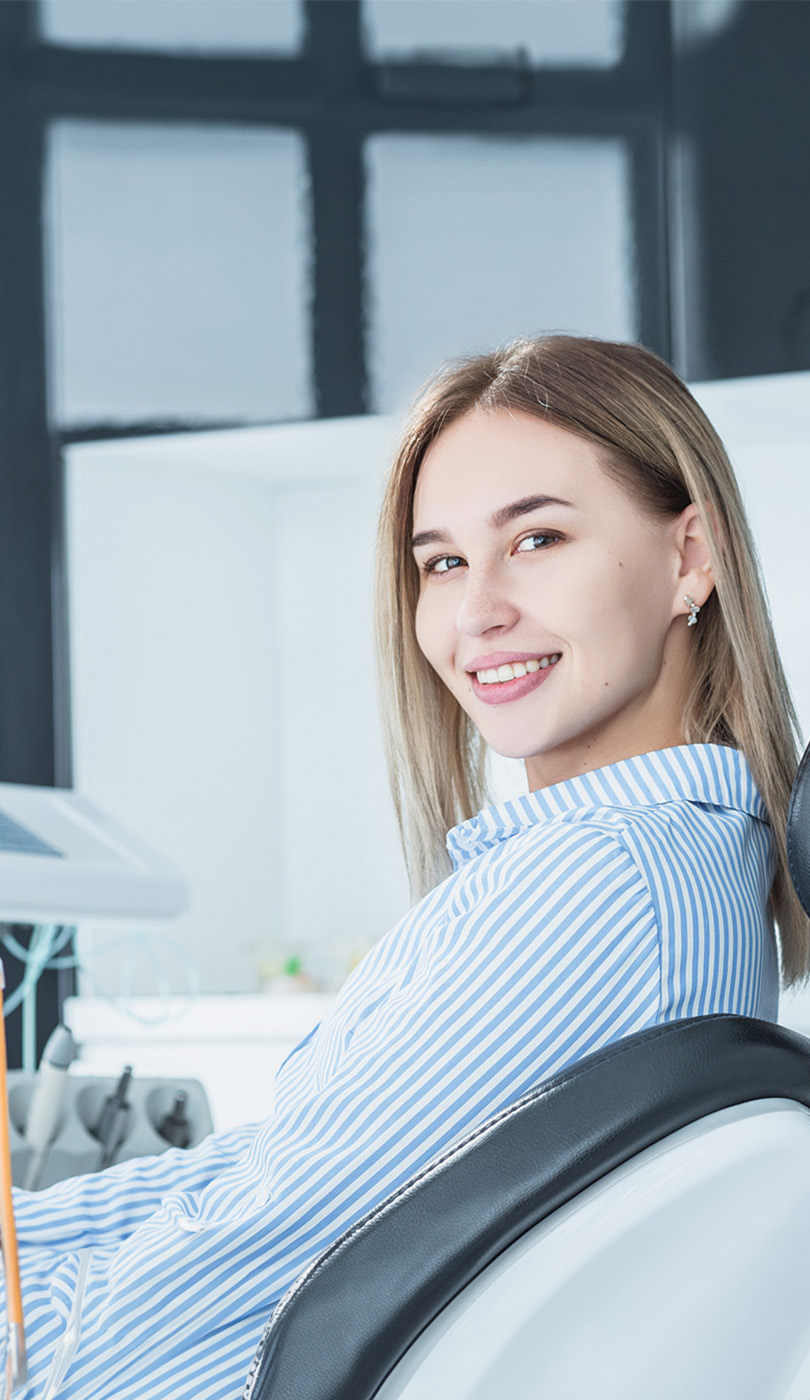 The image shows a modern dental or medical office interior with a dental chair, equipment, and a clean, professional environment.